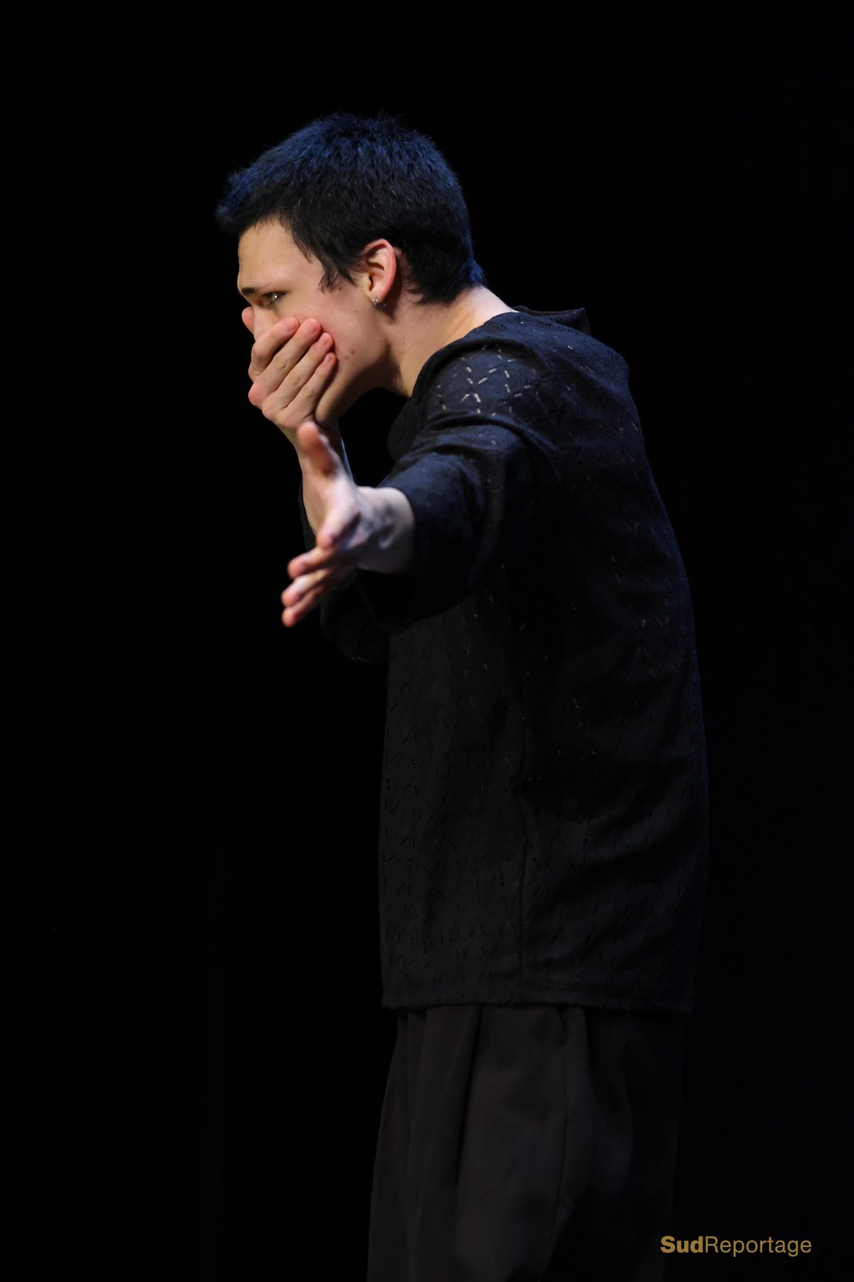 Danseur en costume bordeaux assis sur scène
